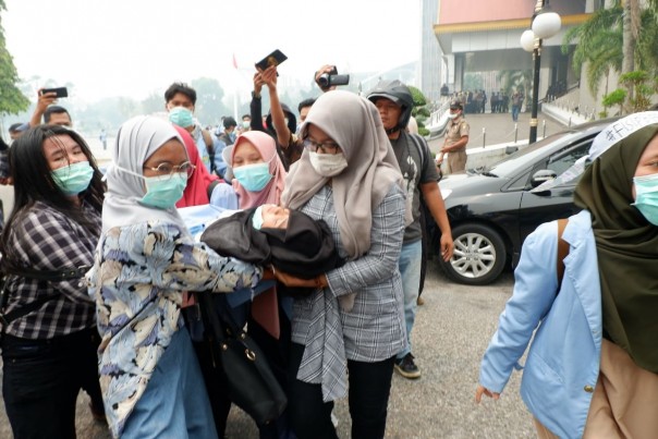 Mahasiswi UNRI yang berdemonstrasi di Kantor Gubernur Riau pingsan di tengah kabut asap (foto/amri)