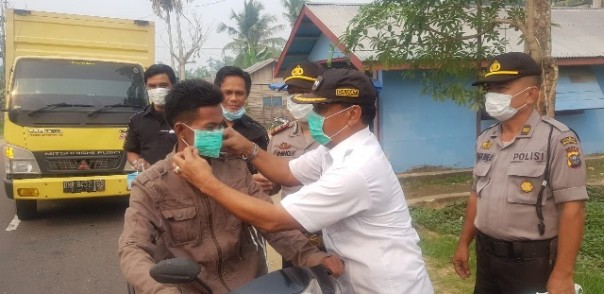 Sekretaris Kesbangpol Inhil Marlis Syarif bersama Forkopimcam Tembilahan Hulu, turun ke jalan membagikan masker untuk masyarakat. Foto: rgo 
