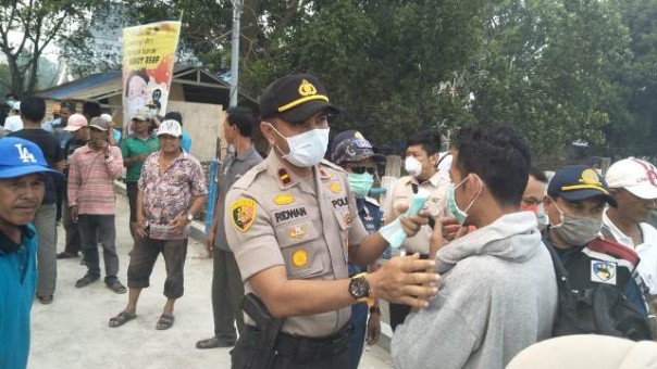Jajaran Polres Inhil membagikan masker bagi masyarakat di Pelabuhan Tembilahan. Foto: rgo