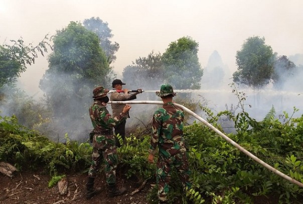 Tim gabungan bersama-sama berjibaku memadamkan api yang membakar lahan di Mandau, Kabupaten Bengkalis. Foto: hari 