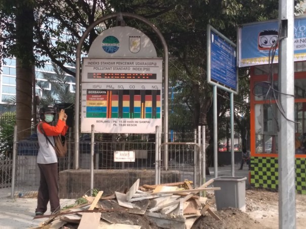 Seorang warga Pekanbaru saat memotret papan ISPU di depan kantor Wali Kota Pekanbaru