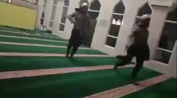 Tangkapan layar dua oknum polisi yang mengenakan sepatu masuk ke dalam masjid untuk mengejar mahasiswa