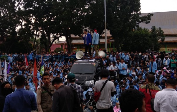 Mahasiswa membacakan tuntutan kepada anggota DPRD Riau melalui pengeras suara
