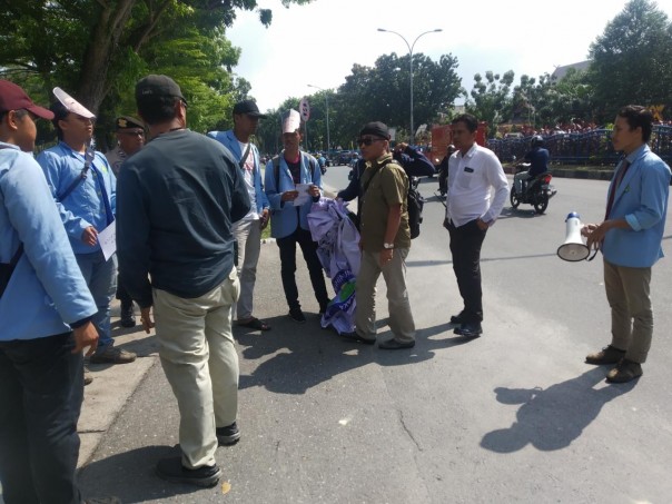 Tak memiliki izin, Kasat Intelkam Polresta Pekanbaru Kompol Sugeng Hariyono (pakai top hitam) membubarkan aksi BEM UNRI di depan kantor DPRD Riau 