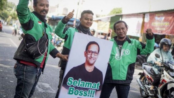 Driver Ojol membentangkan poster berisi ucapan selamat untuk Nadiem Makarim yang diangkat Presiden Jokowi menjadi Mendikbud. Foto: int 
