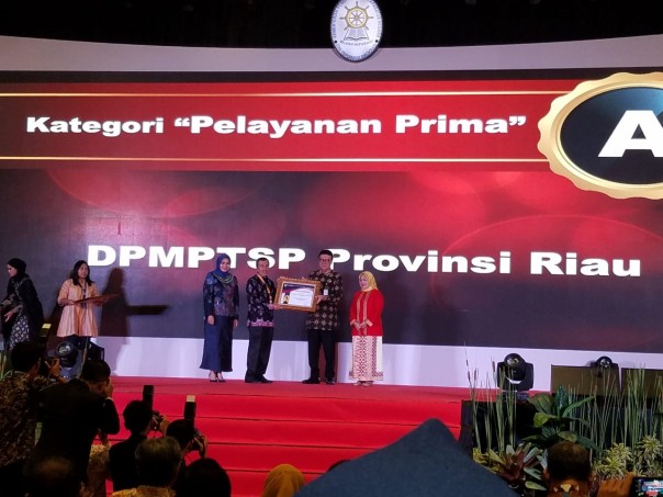 Gubernur Riau, Syamsuar didampingi Kadis DPMPTS Riau, Eva Revita menerim Penghargaan dari Kemenpan RB (Foto: istimewa)