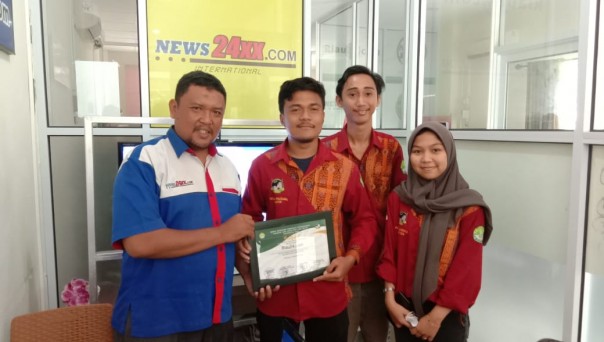 Mayor Korps Mahasiswa Hubungan Internasional (Komahi) UNRI, Fasha Pratama menyerahkan plakat ke Pimpinan Redaksi Riau24.com, Satria Utama Batubara (foto/riki)