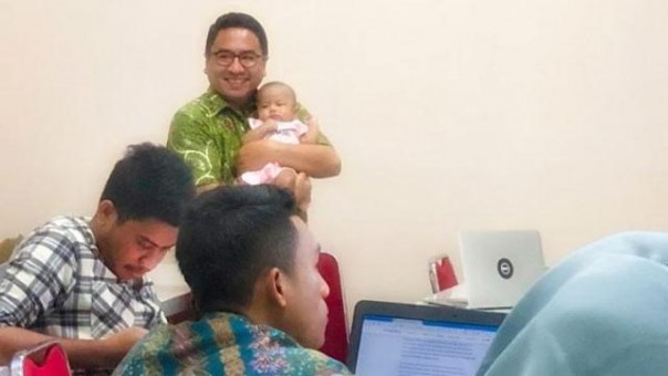 Abdul Gaffar menggendong bayi saat mengajar di kelas. Tindakannya menuai pujian dari netizen di Tanah Air. Foto: int  