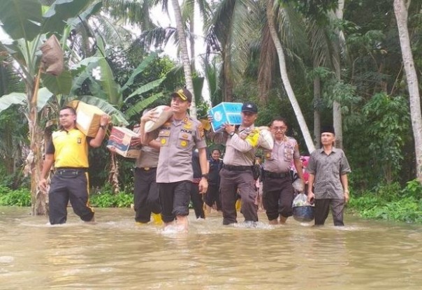 Jajaran Polres Kampar menembus banjir untuk menyalurkan bantuan kepada warga yang rumahnya terendam. Foto: int 