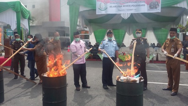 Ketua DPRD Kota Pekanbaru saat ikut melakukan pemusnahan barang bukti tindak pidana umum di Kejari Pelanbaru. (R24/put)