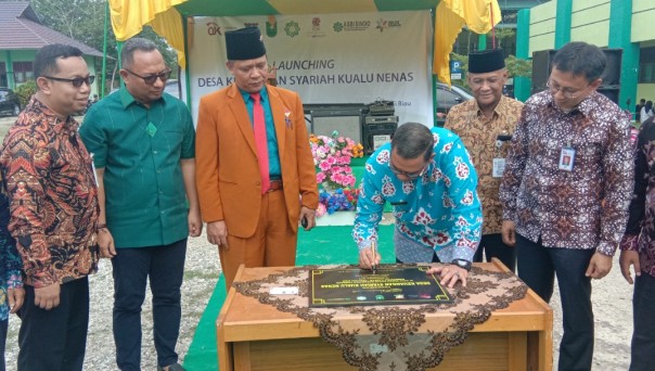 Kepala OJK Riau, Yusri saat mendampingi Wakil Gubernur Riau, Edy Natar Nasution menandatangani prasasti launching desa perekonomian syariah di Desa Kualu Nenas, Kampar