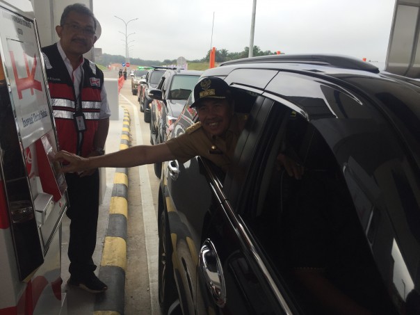 Gubernur Riau, Syamsuar saat melalui gerbang tol Pekanbaru Dumai untuk tap gerbang tol pertama kali. (R24/put)