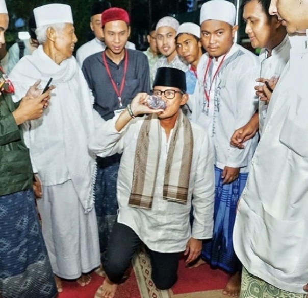 Sandiaga Uno minum sambil duduk (foto/int)