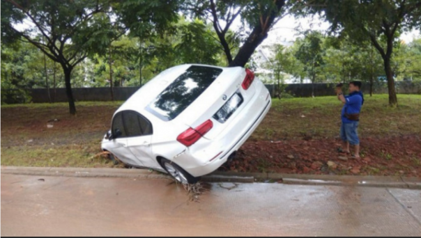 Mobil BMW warna putih nyangkut di pohon setelah sempat terseret banjir di Jakarta. Foto: int 