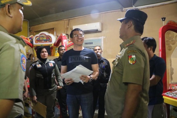 Kepala Satpol-PP Kota Pekanbaru. Agus Pramono saat melihat dokumen perizinan kepada pengelola tempat hiburan malam. (R24/rls)