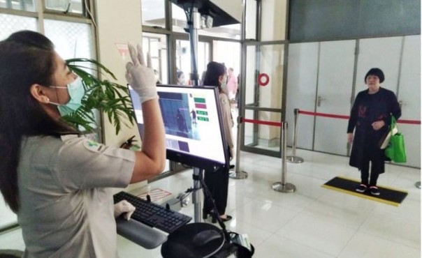 Petugas di bandara mendeteksi suhu badan penumpang sebagai antisipasi penyebaran virus Corona. Foto: int 