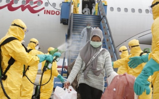 WNI langsung disirami cairan disinfektan begitu mendarat di Bandara Hang Nadim, Batam, Kepulauan Riau. Foto: int 