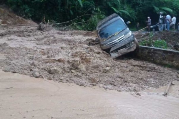 Satu unit mobil terseret lumpur saat longsor menimpa Kabupaten Limapuluh Kota, Sumbar. Senin 3 Februari 2020. Untuk sementara, lintas Riau-Sumbar terputus total. Foto: int  