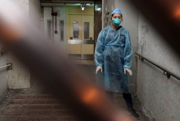 Petugas berpakaian pelindung menyisir bangunan yang diduga terinfeksi virus Corona di Hong Kong. Seluruh warga penghuni gedung dievakuasi setelah dua orang penghuninya terinfeksi Corona. Foto: int 