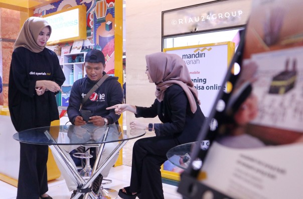 Salah seorang nasabah baru bernama Dermawansyah tengah mencoba fitur pendaftaran online membuka rekening baru di Mall SKA Pekanbaru.