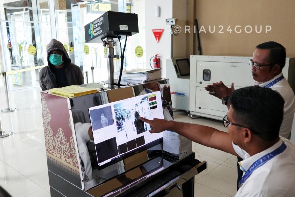 Petugas Bandara SSK II Pekanbaru tengah memeriksa penumpang dengan Thermal Scanner untuk mengantisipasi masuknya virus Corona. (Foto. Amri) 