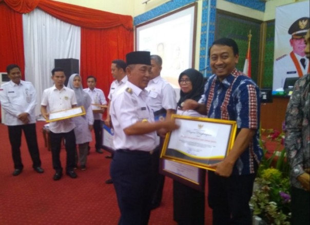 Bupati Pelalawan H M Harris memberikan penghargaan CSR terbaik kepada PT RAPP (foto/ist)