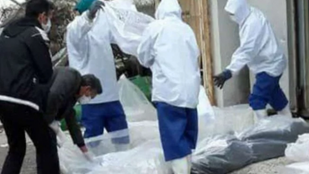 Petugas mengurus jenazah salah seorang pasien pengidap virus Corona di Iran. Foto: int 