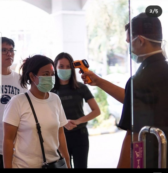 Salah satu petugas Mal di Pekanbaru melakukan tes suhu tubuh setiap pengunjung sebagai antisipasi virus corona