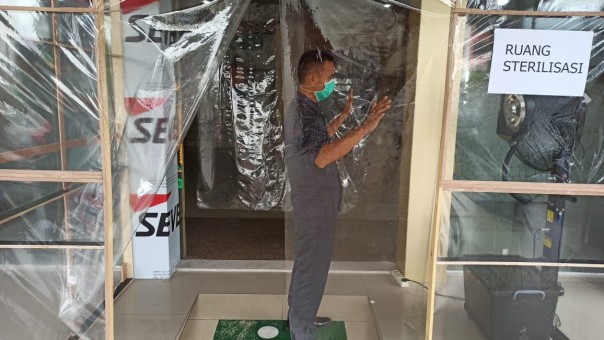 Seorang pegawai Kejari Pekanbaru tengah disemprot disinfectan diruangan yang telah disiapkan. Foto istimewa
