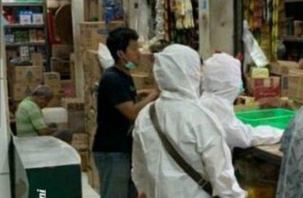 Dua orang yang berbelanja ke pasar tradisonal menggunakan hazmat, akhirnya dihujat netizen. Foto: int 