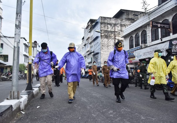 Bupati Kabupaten Indragiri Hilir (Inhil), HM Wardan bersama tim gugus tugas covid-19 melakukan penyemprotan disinfektan ke sejumlah pusat keramaian (foto/Rgo)