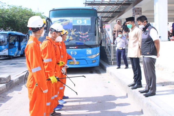 Tim Dompet Dhuafa Riau melakukan penyemprotan disinfektan di halte dan Transmetro Pekanbaru. (Foto: Istimewa)