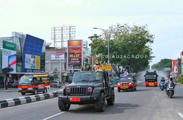 Kegiatan penyemprotan cairan disinfektan oleh mobil AWC Polda Riau disejumlah ruas jalan protokol di Pekanbaru. (Foto. Amri)