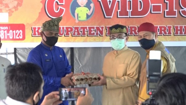 Bupati Indragiri Hilir (Inhil) HM Wardan, menyerahkan bantuan paket sembako ke masyarakat di Kecamatan Tembilahan (foto/Rgo)