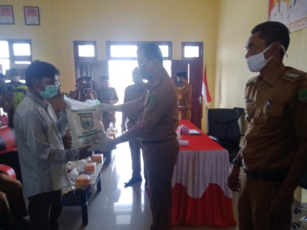 Bupati Rokan Hilir Suyatno menyerahkan bantuan sembako untuk warga yang terdampak Covid-19 di Kecamatan Sinaboi (foto/int)