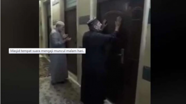 Dua warga berdiri di depan pintu utama masjid yang kondisinya kosong, sementara dari dalam terdengar riuh suara seperti orang mengaji. Foto: int 