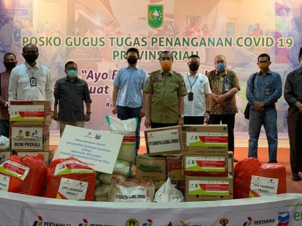  Area Manager EMP Bentu Ltd, Yoyok S Purwanto (berdiri di sebelah kanan Gubri) saat menyerahkan bantuan sembako dari  EMP kepada Pemprov Riau di Gedung Daerah. Foto: ist 