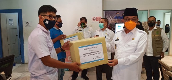 Bupati Kabupaten Indragiri Hilir (Inhil), HM Wardan menyerahkan bantuan sembako bagi para jurnalis yang bertugas meliput di Kabupaten Inhil (foto/ist)