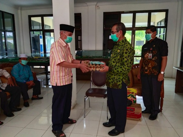 Bupati Kuantan Singingi Drs. H. Mursini. M.Si menyerahkan bantuan sembako kepada para Ustad/Ustazah, se Kecamatan Kuantan Tengah (foto/Zar)