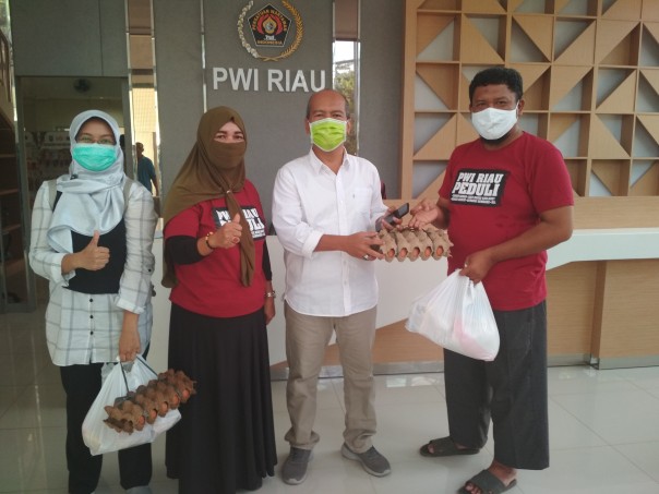 Sekretaris PWI Riau Peduli,  Satria Batubara menyerahkan bantuan paket sembako kepada wartawan 