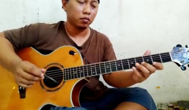 Alip Ba Ta gitaris sederhana asal Ponorogo yang mendunia sedang bermain gitar dengan cara digesek (foto/int)