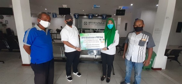 Kepala BPJS Kesehatan Cabang Pekanbaru Nora Duita Manurung menyerahkan masker kepada Sekretaris PWI Riau Amril di Kantor BPJS