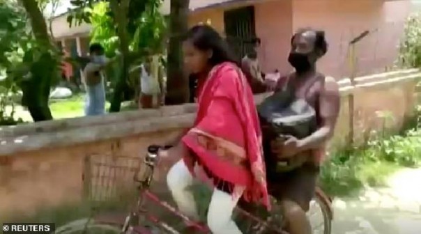 Kumari membonceng ayahnya naik sepeda untuk pulang kampung