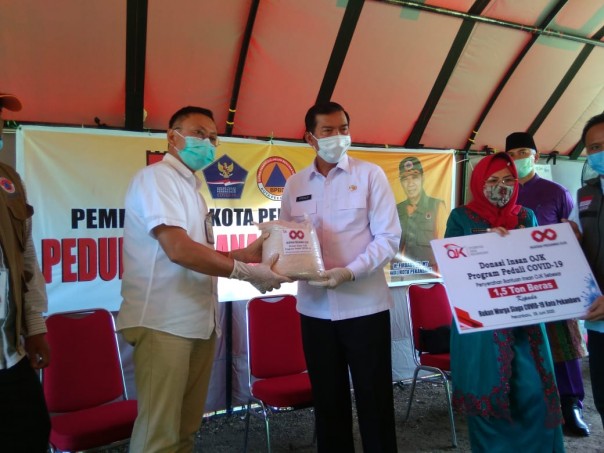 Walikota Pekanbaru menerima bantuan dari OJK secara simbolis