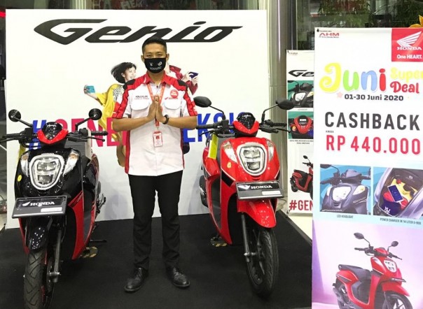 Petugas Dealer sedang berpose dengan Honda Genio yang didisplay di dalam showroom