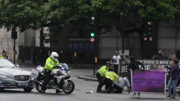Polisi Inggris mengamankan demonstran yang berusaha mengejar konvoi kendaraan PM Inggris Boris Johnson. Foto: int 