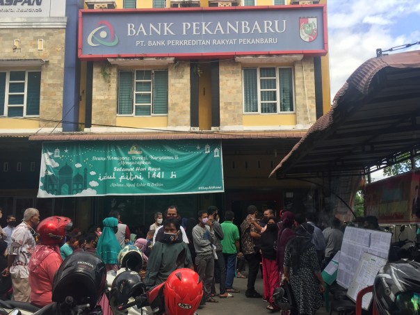 Penampakan masyarakat berkerumun mengantri bantuan sosial tunai di Bank Perkreditan Rakyat Pekanbaru