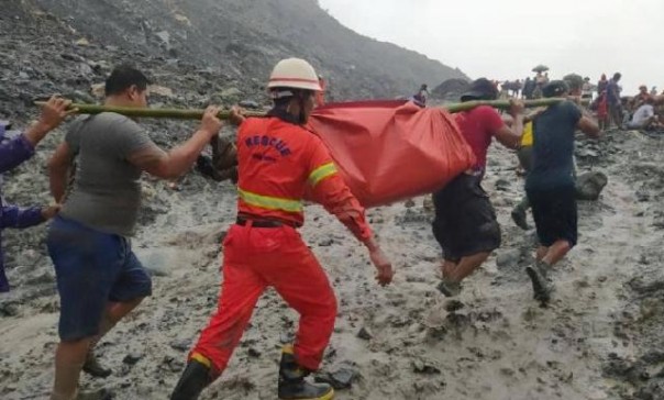 Petugas mengevakuasi salah satu jenazah yang menjadi korban longsor di penambangan batu giok di Myanmar. Foto: int