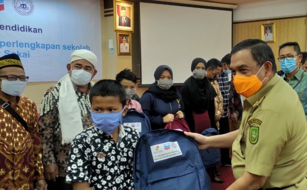 Wagubri Edi Natar Nasution menyerahka  bantuan peralatan sekolah kepada anak-anak Sakai