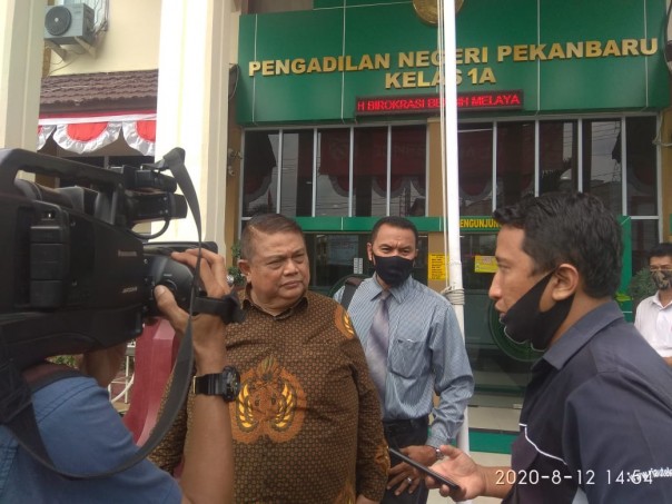E. Sangur, SH, MH, mendampingi DR. Nudirman Munir SH, MH saat diwawancara wartawan usai sidang di PN Pekanbaru (foto/ist)